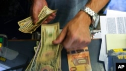 FILE - A cashier changes a 50 euro banknote for U.S. dollars in Rome, July 13, 2022. Rising energy prices have fueled inflation in Italy and other European countries. Annual inflation in the eurozone’s 19 countries rose to 9.1% in August, up from 8.9% in July, the EU statistics agency said.
