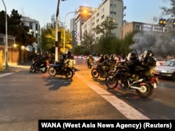 FILE - Police arrive to disperse demonstrators during a protest over the death of Mahsa Amini, a woman who died after being arrested by the Islamic republic's "morality police," in Tehran, Iran, Sept. 19, 2022.