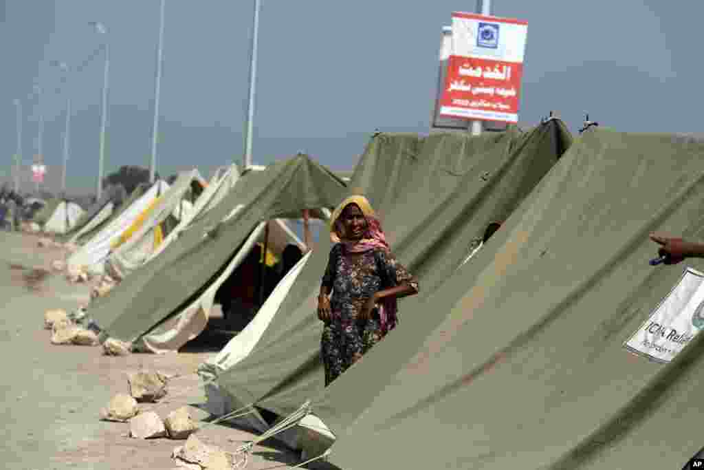 An affected woman takes refuge in a tent area after her home was hit by floods in Sukkur, Pakistan, Sept. 4, 2022.