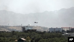 一架美制黑鷹軍用直升機飛過喀布爾上空。(2021年8月15日) 