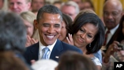 Presiden Barack Obama dan ibu negara Michelle Obama menghadiri peluncuran potret mantan President George W. Bush dan mantan ibu negara Laura Bush di Gedung Putih, 31 Mei 2012. (Foto: Carolyn Kaster/AP Photo)