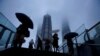 Warga membawa payung di tengah hujan saat Topan Chanthu mendekat, di Shanghai, China 13 September 2021. (REUTERS/Aly Song)
