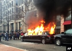 Para demonstran membakar sebuah limusin yang terparkir di pusat Kota Washington sebagai protes pelantikan Presiden Donald Trump, 20 Januari 2017.