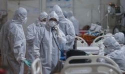 Seorang dokter berbicara melalui interkom dengan konsultan senior memberikan informasi terbaru tentang pasien di rumah sakit khusus untuk perawatan pasien COVID-19 terbesar di Mumbai, India, Kamis, 6 Mei 2021. (AP Photo / Rafiq Maqbool)