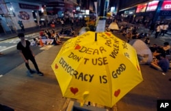 FILE - An umbrella with pro-democracy messages above the student-led protest site in the Mong Kok district of Hong Kong, Monday, Oct. 20, 2014.