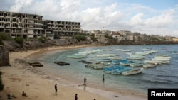 FILE - People stand and walk on a beach in the old port of Mogadishu, Somalia, Nov. 13, 2013. Global watchdog Transparency International said Wednesday its latest annual Corruption Perceptions Index report showed pervasive public-sector corruption around the world. Somalia remained the worst performer with a score of 10, followed by South Sudan, with a score of 11.