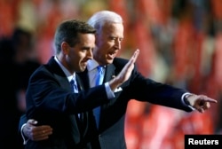 FILE - Attorney General Beau Biden (D-DE) (L) and Vice Presidential candidate Senator Joe Biden (D-DE) gesture on stage at the 2008 Democratic National Convention in Denver, Colorado August 27, 2008.