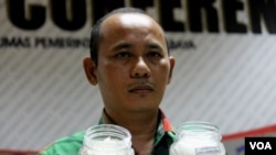 Petani Garam asal Surabaya, Muhammad Nur Aini menunjukkan garam produksinya (Foto: VOA-Petrus Riski).