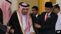 Presiden Joko Widodo membantu Raja Salman berjalan dalam pertemuan mereka di Istana Bogor (1/3). (AP/Achmad Ibrahim)