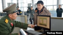 개성공단 전자출입체계(RFID) 시스템이 28일 본격적인 시범 가동에 들어간 가운데 북측 출입사무소의 직원이 전자시스템을 이용해 개성공단 출입 심사를 하고 있다.