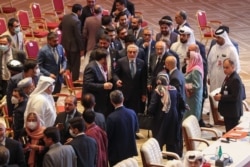 Abdullah Abdullah (C), Chairman of Afghanistan's High Council for National Reconciliation, speaks with negotiators at the end of a session during peace talks between the Afghan government and the Taliban, in Doha, Qatar, Sept. 12, 2020.