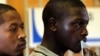 FILE - A man holds his identity book as he waits to cast his vote in Eden Park, south of Johannesburg, South Africa.