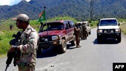 Petugas berpatroli di dekat Kota Wabag, 600 kilometer barat laut ibu kota Port Moresby. Enam puluh empat mayat ditemukan di dataran tinggi Papua Nugini akibat perang antarsuku. (Foto: via AFP)