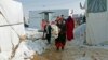 A Syrian refugee family carries 18-day-old triplets, whose mother died during childbirth in a nearby hospital, in a refugee camp near Zahle town in the Bekaa Valley, Lebanon, Jan. 18, 2015.
