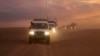 This photo released by the Syrian Arab Red Crescent, shows a convoy of vehicles of the Syrian Arab Red Crescent driving in the Syrian desert heading to Rukban camp between the Jordan and Syria borders, Nov. 4, 2018.