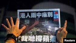 一名苹果日报的支持者手拿最后一期的苹果日报。（路透社2021年6月24日）