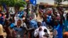 Supporters of Uganda's main opposition presidential candidate Kizza Besigye gesture while standing next to an effigy of him during a Feb. 10 campaign rally in Kampala.
