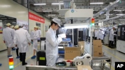 แฟ้ม - พนักงานทำงานในส่วนผลิตโทรศัพท์มือถือของ Huawei ในมณฑลกวางตุ้ง จีน 6 มี.ค. 2019 (AP Photo/Kin Cheung, File)