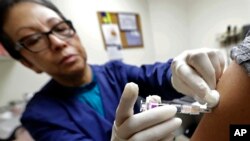 Seorang perawat AS memberikan suntikan vaksin flu di sebuah klinik di Seattle, Washington (foto: ilustrasi). 
