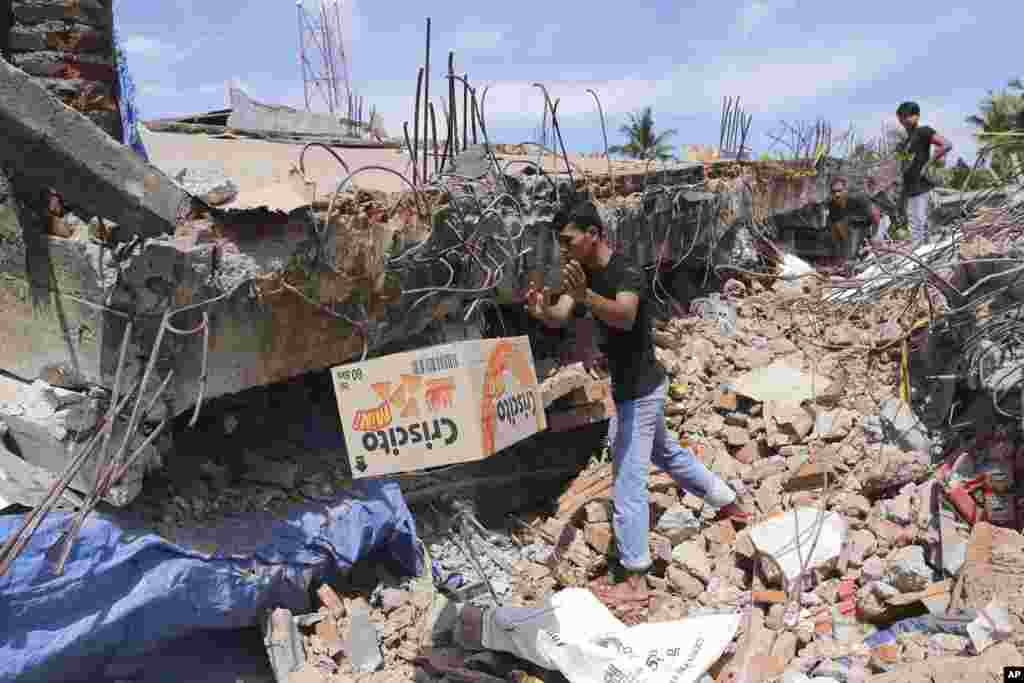 Warga memindahkan sekardus makanan dari bawah puing-puing bangunan yang ambruk akibat gempa di Pidie Jaya, Aceh (7/12). (AP/Heri Juanda)