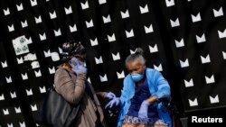 People seen along along 53rd Street wear personal protective equipment during the global outbreak of coronavirus disease (COVID-19) in Chicago, Illinois, April 7, 2020.