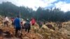 Orang-orang melintasi area longsor untuk sampai ke sisi lain di desa Yambali, Papua Nugini, Jumat, 24 Mei 2024. Lebih dari 100 orang diyakini tewas dalam bencana tanah longsor di negara kepulauan Pasifik Selatan itu. (Benjamin Sipa/Organisasi Internasional untuk Migrasi via AP)