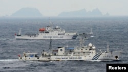 An aerial photo shows Chinese marine surveillance ships Haijian No. 49 (front) and Haijian No.50 cruising in the East China Sea, as the islands known as Senkaku isles in Japan and Diaoyu islands, April 23, 2013.