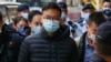 Pemimpin redaksi Stand News Patrick Lam dibawa menuju kantor media tersebut dengan tangan terborgol setelah polisi menggerebek media tersebut pada 29 Desember 2021. (Foto: AFP/Daniel Suen)