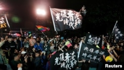 FILE - Hong Kong anti-government protesters attend a rally in support of Taiwan President Tsai Ing-wen outside the Democratic Progressive Party (DPP) headquarters in Taipei, Taiwan, Jan. 11, 2020. 