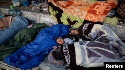 Refugees and migrants from the destroyed Moria camp sleep on the side of a road, on the island of Lesbos, Greece, Sept. 13, 2020.