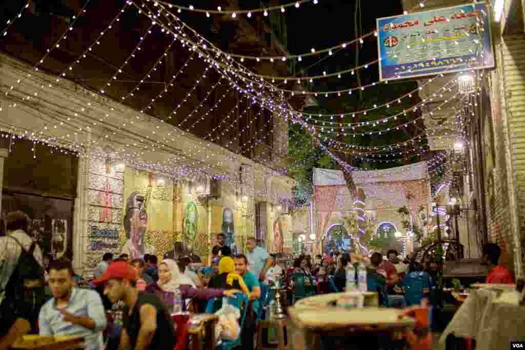 The introduction in recent years of lower-consumption LED bulbs mean many Cairo residents, like patrons and this street café, can continue to enjoy bright lights on a summer’s eve. (H. Elrasam/VOA)