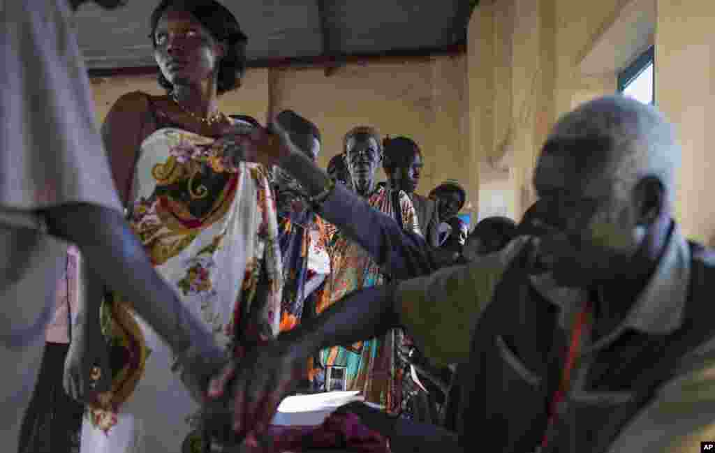 Voters wait in line to cast their vote, as others have their fingers dipped in ink to show they have done so, in an abandoned school used as a polling center in the disputed border region of Abyei, Oct. 27, 2013.