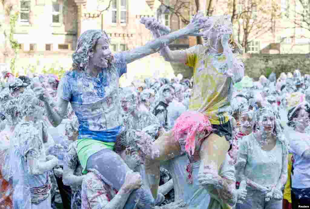 Students from St.Andrews University are covered in foam after taking part in the traditional "Raisin Weekend" in the Lower College Lawn, at St. Andrews in Scotland, Britain.