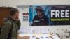 A Tibetan exile in Dharmsala, India, walks past a banner demanding the release of Tashi Wangchuk, an outspoken campaigner for the rights of Tibetans to receive instructions in Tibetan language, who was arrested in 2016 in China's Qinghai province for allegedly inciting separatism, Jan. 27, 2017. 