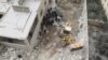 Civil defense workers remove dead bodies from under debris after an airstrike on Kafr Hamra village in the northern Aleppo countryside of Syria, Feb. 27, 2016.