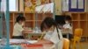 Siswa menggunakan sekat plastik untuk mencegah penyebaran Covid 19 di International Pioneers School di Bangkok. (Foto: AFP)