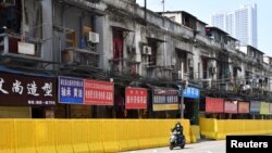 2010年3月5日，一名戴上口罩的男子在湖北武漢市的街道上騎自行車。