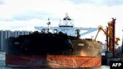 FILE - A tanker unloads crude oil at the port in Qingdao, in China's eastern Shandong province, Nov. 16, 2020.