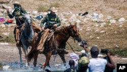 Anggota pasukan penjaga perbatasan AS berusaha mencegah migran Amerika Tengah yang berusaha menyeberangi sungai Rio Grande dari kota Ciudad Acuña, Meksiko menuju kota Del Rio, Texas (foto: dok). 