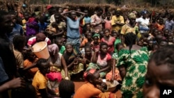 FILE - Displaced people who fled Bangassou wait for food distribution in the village where they found refuge, Siwa, Central African Republic, Feb. 13, 2021.