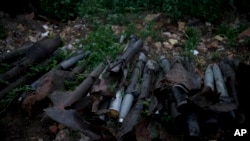 Sejumlah granat dan beberapa senjata lainnya tergeletak di pinggir jalan dekat Kota Makariv, di pinggiran kota Kyiv, pada 14 Juni 2022. (Foto: AP/Natacha Pisarenko)