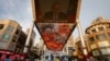 A screen shows a CCTV state media news broadcast of Russian President Vladimir Putin, addressing the BRICS Business Forum via video link, at a shopping center in Beijing, June 23, 2022.