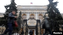 People walk past the Central Bank headquarters in Moscow, Russia on Feb. 11, 2019.