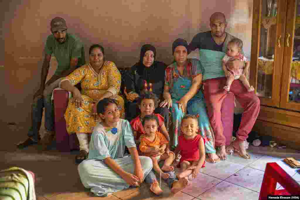 Mohamed (left) and his family live in this two-bedroom apartment. The daily wages of their household’s three men (two pictured) help supplement rations of state-subsidized bread with unsubsidized loaves. Old Cairo, July 5, 2022. (Hamada Elrasam/VOA)