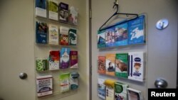Pamflet informasi tergantung di belakang pintu Women's Health Clinic di Winnipeg, Manitoba, Kanada, yang menawarkan layanan perawatan reproduksi, termasuk aborsi, 28 Juni 2022. (REUTERS/Shannon VanRaes)