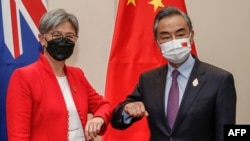 2022年7月8日，在印尼度假勝地巴釐島努沙杜瓦舉行的二十國集團外長會議期間，澳大利亞外交部長黃英賢(左)與中國外交部長王毅碰肘互致問候。(法新社照片)