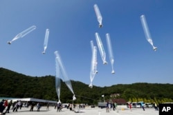 지난 2014년 10월 한국 경기도 파주에서 탈북민단체 회원들이 대북전단이 매달린 풍선을 북쪽으로 날리고 있다.
