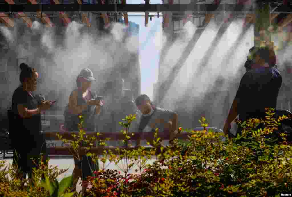 People take a break under a cooling mist as the Japanese government issues a warning over a possible power crunch due to a heatwave in Tokyo, Japan.
