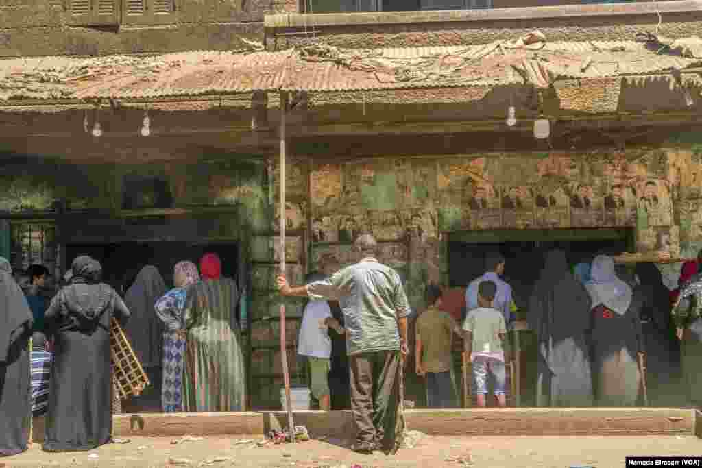 Families wait for loaves of subsidized bread. The World Bank says its loan will finance a month’s worth of imported wheat for Egypt’s bread subsidy program, which supports around 70 million low-income Egyptians. Cairo, July 7, 2022. (Hamada Elrasam/VOA)