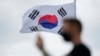 A visitor uses a smartphone to film at the unification observatory in Paju, South Korea, July 7, 2022. 